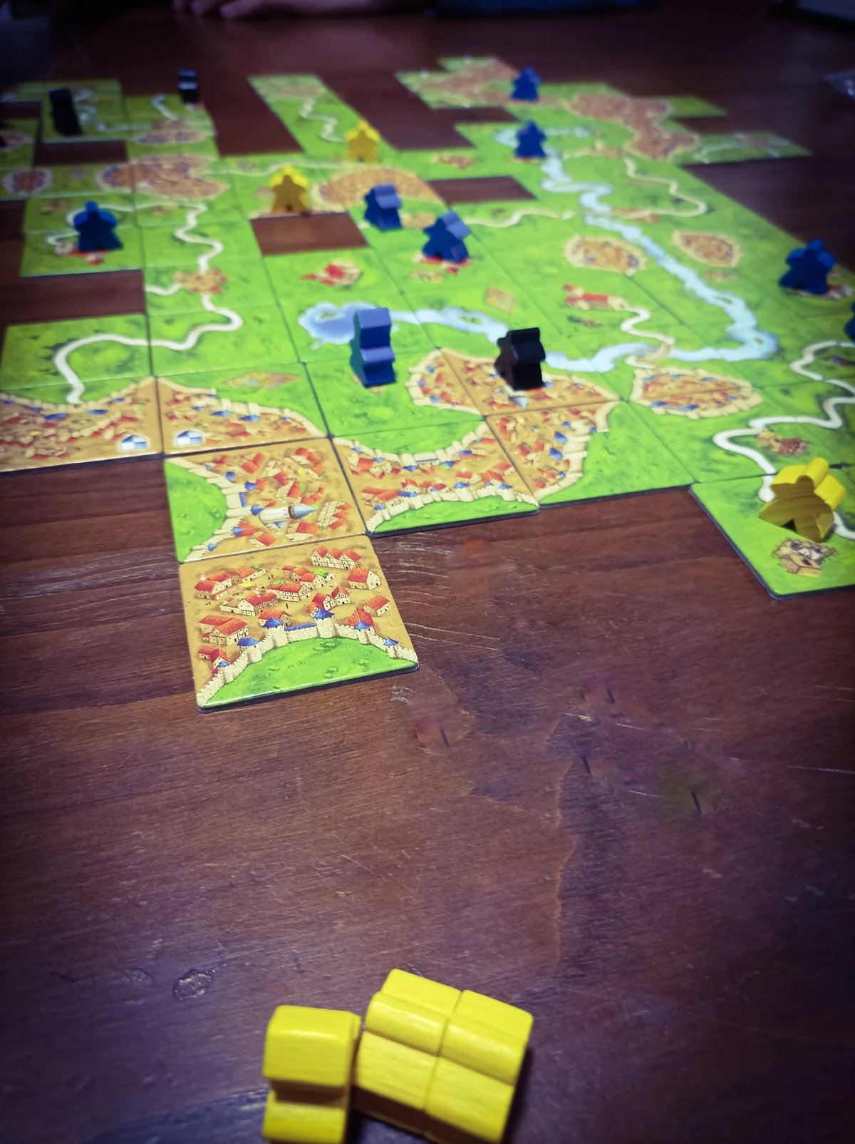 Caja del juego de mesa Carcassonne con tiles y meeples